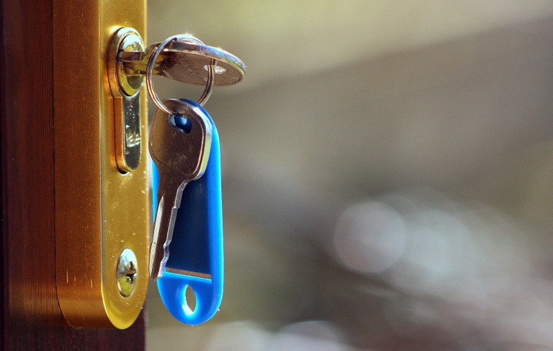 House keys with a blue tag sitting in a lock