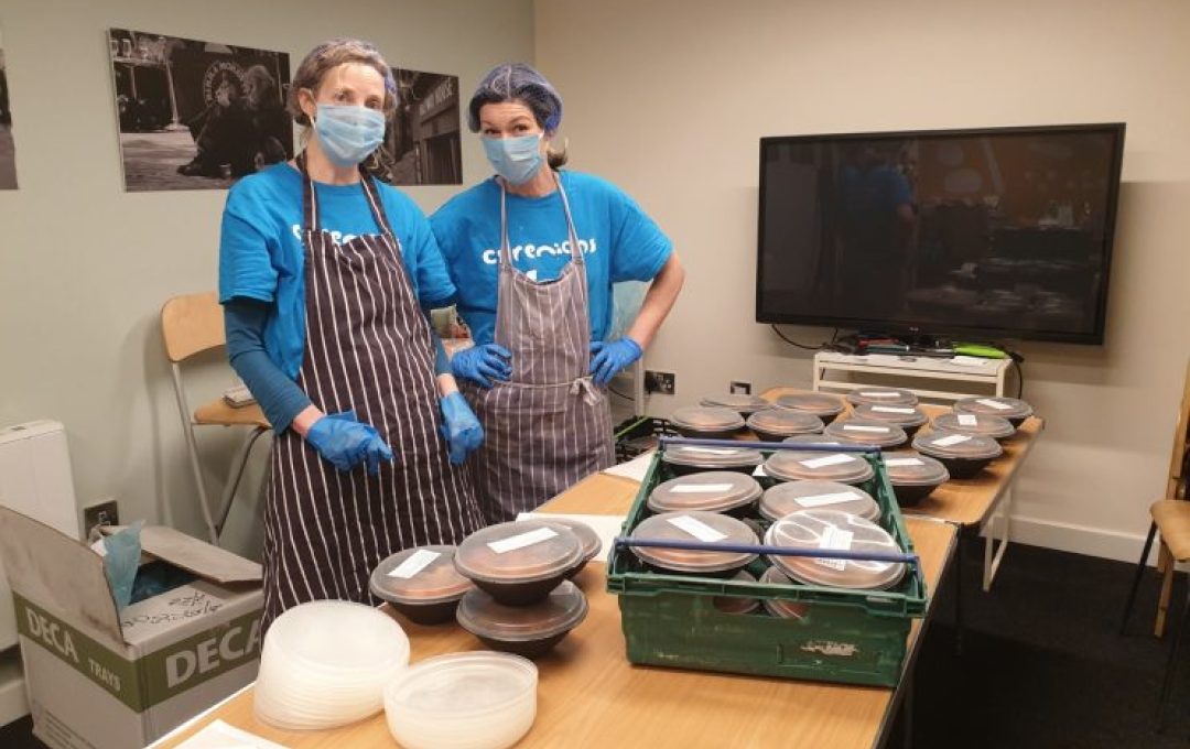 2 people prepare meals for delivery