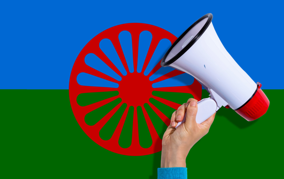 A Traveller flag overlaid with a hand holding a megaphone